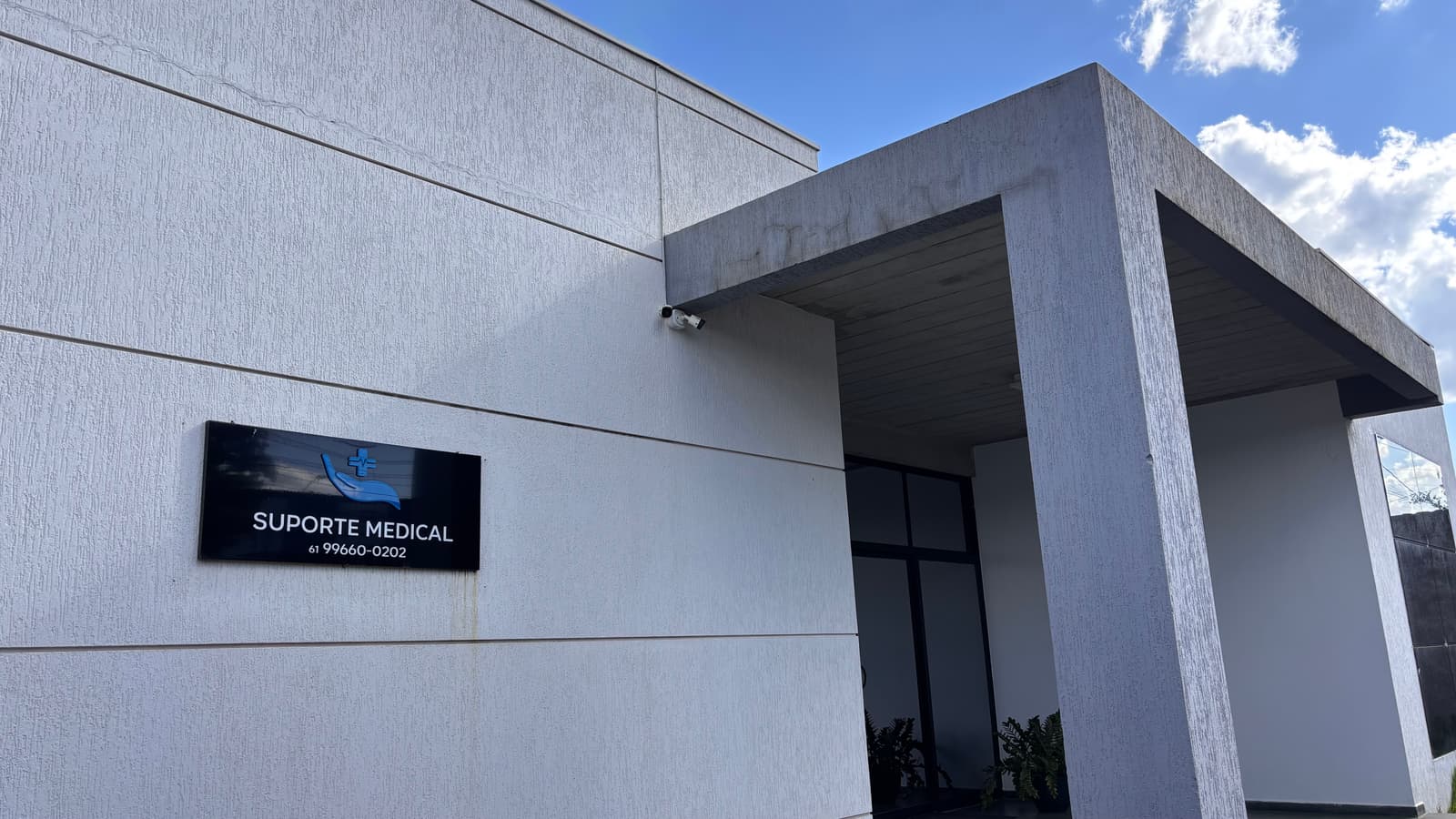 A loja da Suporte Medical em Águas Claras: prédio branco com a placa da empresa ao lado da entrada.